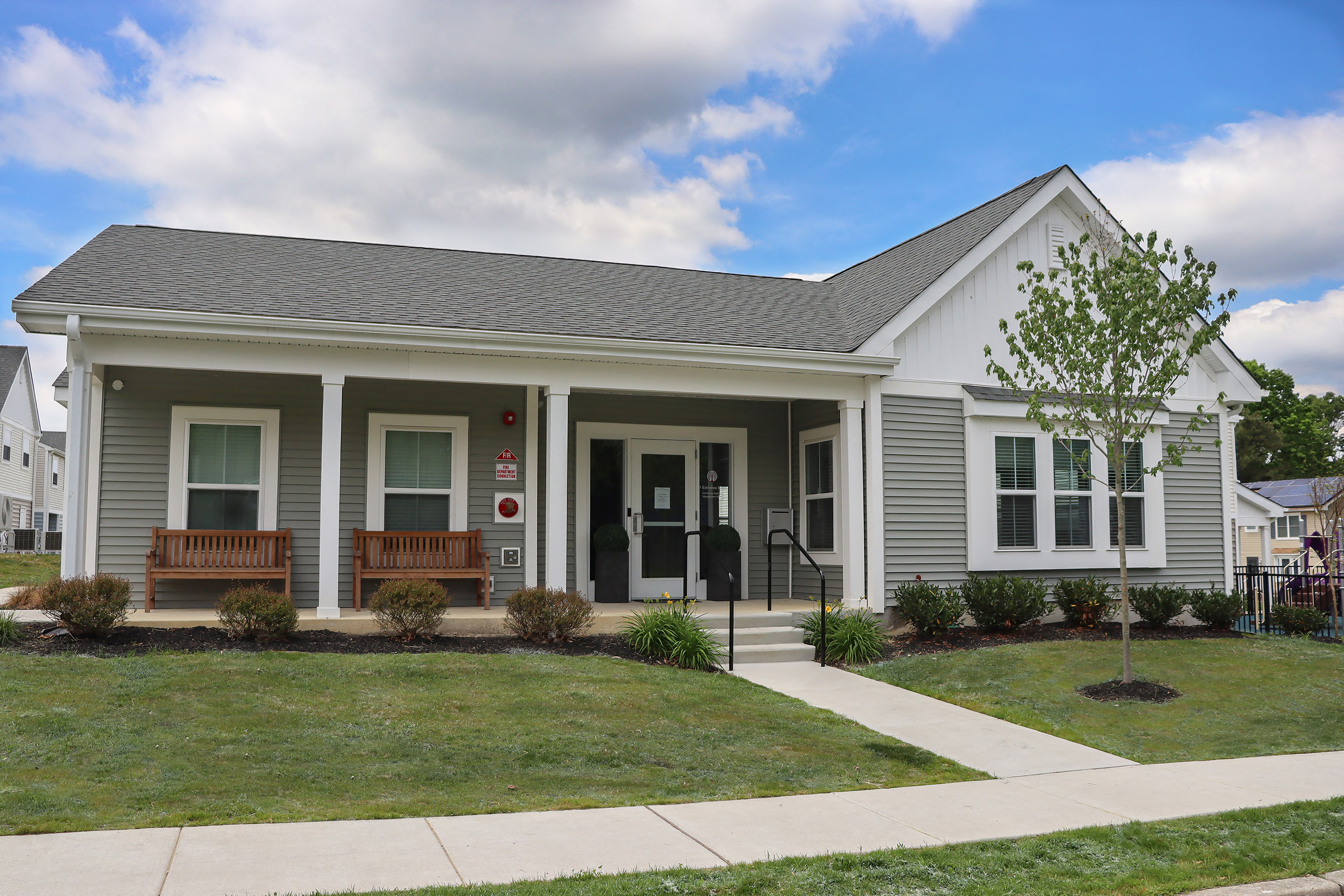 a white house with a lawn and a sidewalk in front of it